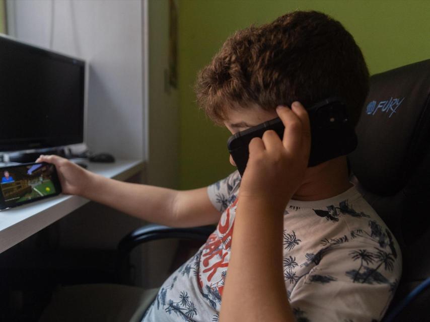 Un niño utilizando sus teléfonos móviles.