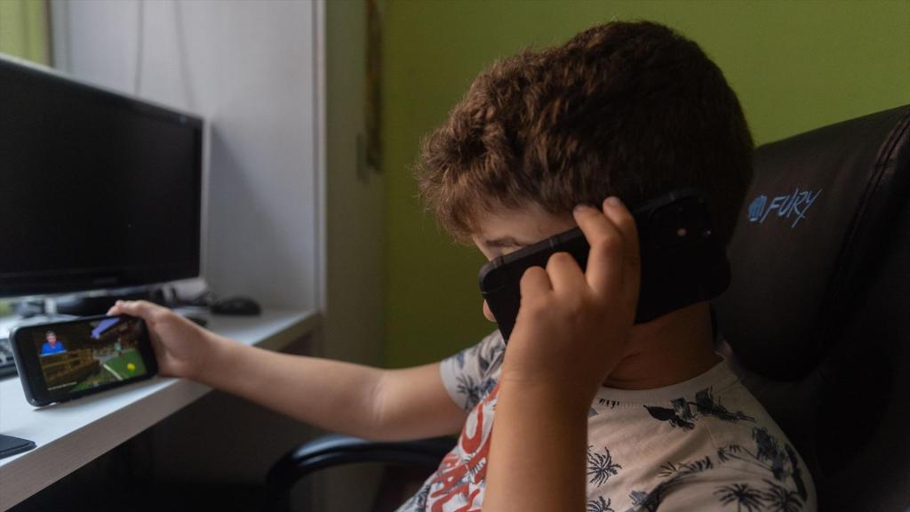Un niño utilizando su teléfono móvil.