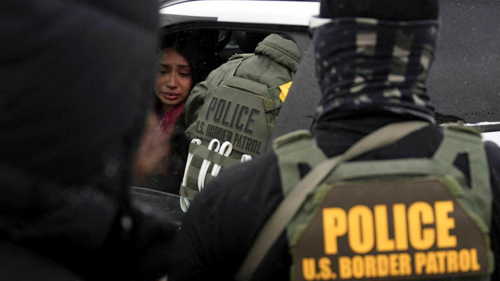 Una mujer anónima con gesto afligido frente a agentes federales durante las protestas.