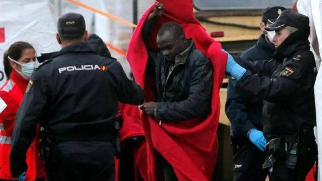 Un inmigrante en situación irregular, custodiado por policías nacionales, a su llegada al puerto de Málaga, en diciembre de 2016.