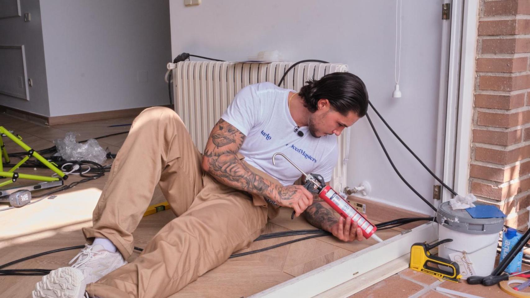 Carlo Costanzia aplicando silicona en un ribete de una ventana en 'DecoMasters'.