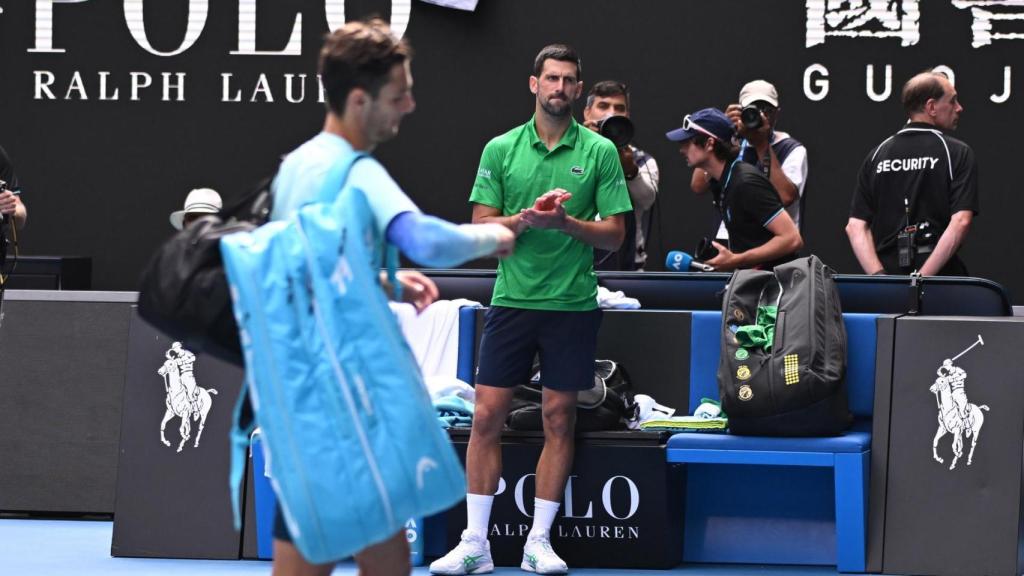 Djokovic aplaude mientras, al frente, Musetti abandona la pista por lesión
