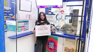 Cristina con el cartel de los 7,2 millones que dio su administración en La Bonoloto este sábado.