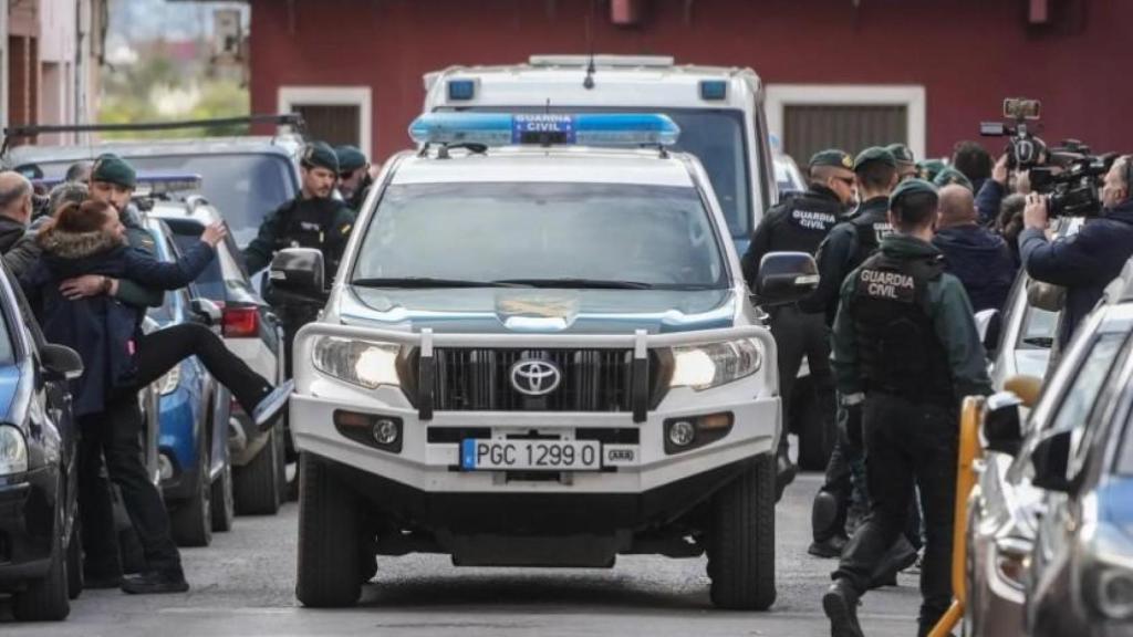 Una mujer trata de darle una patada al coche patrulla que trasladaba a Juan Francisco, este martes, a los juzgados de Sueca.