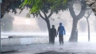 Una pareja se refugia de la lluvia debajo del puente de Triana, en Sevilla, al paso de la borrasca Joseph.