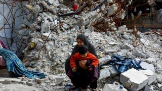 Palestinos caminan entre los escombros de edificios residenciales destruidos durante la guerra , en la ciudad de Gaza.