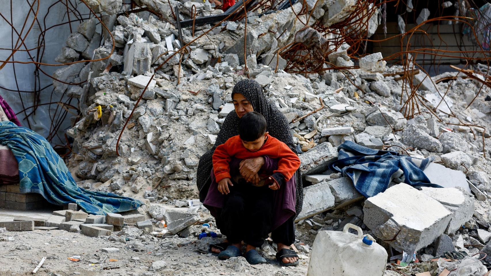 Palestinos caminan entre los escombros de edificios residenciales destruidos durante la guerra , en la ciudad de Gaza.