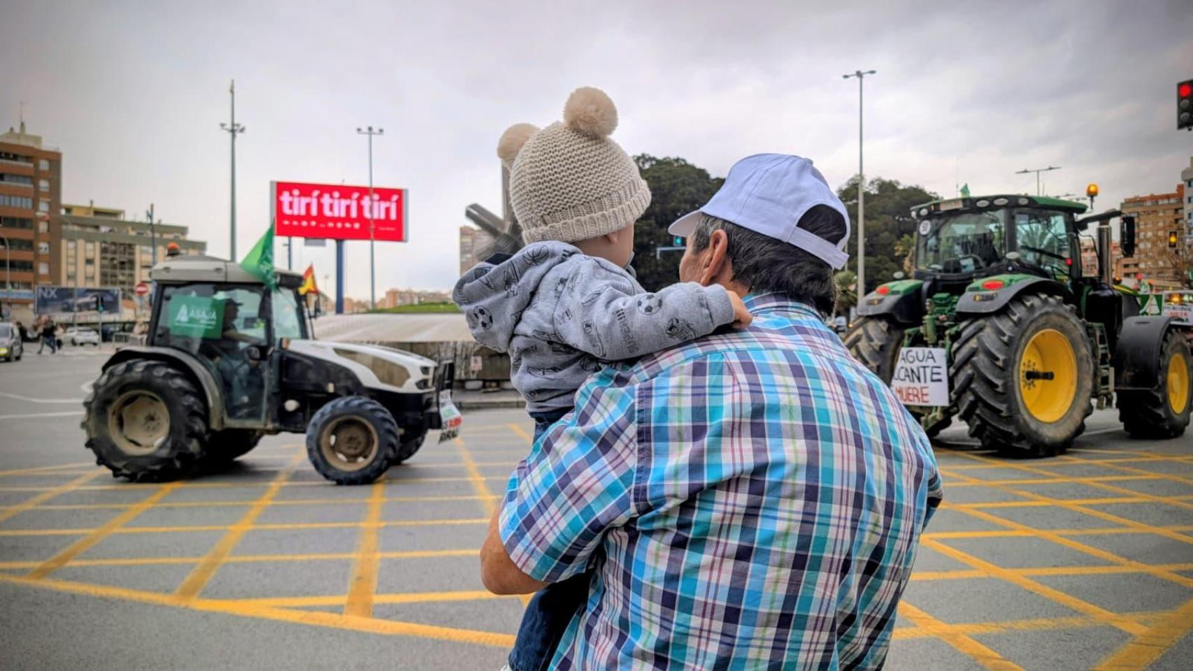 Un abuelo acude con su nieto a una tractorada en Alicante.