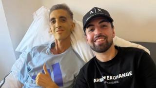 Xisco Quesada postrado en la cama del hospital junto a su hermano.