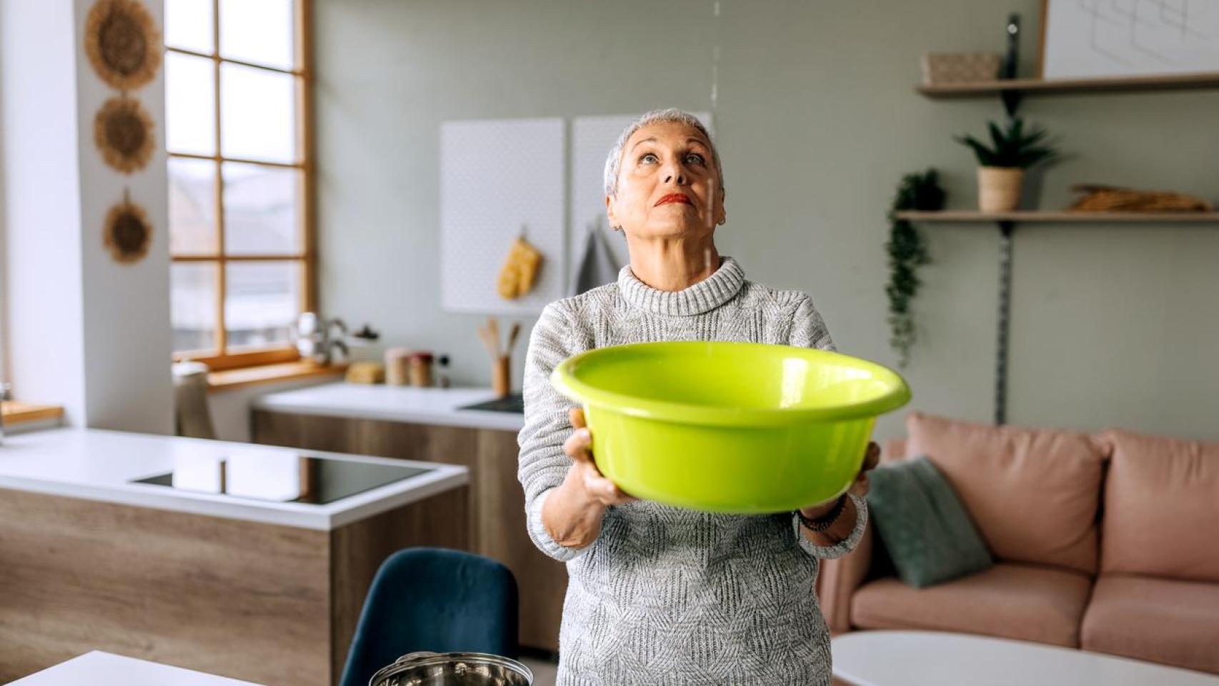 Una mujer con una gotera en casa.