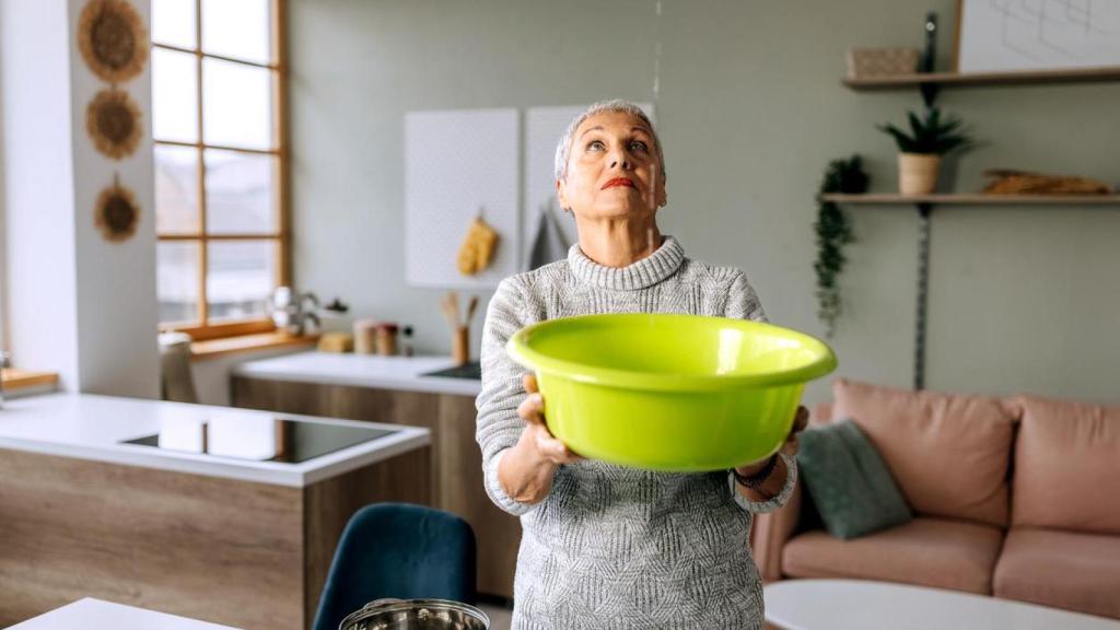 Una mujer con una gotera en casa.