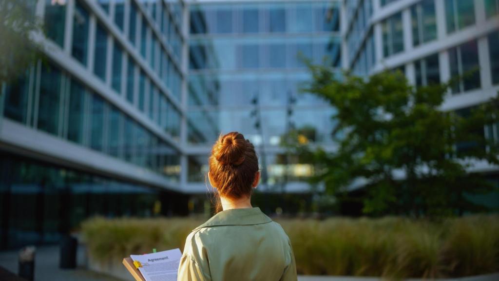 Visto desde detrás de una mujer de negocios cerca del edificio de oficinas.