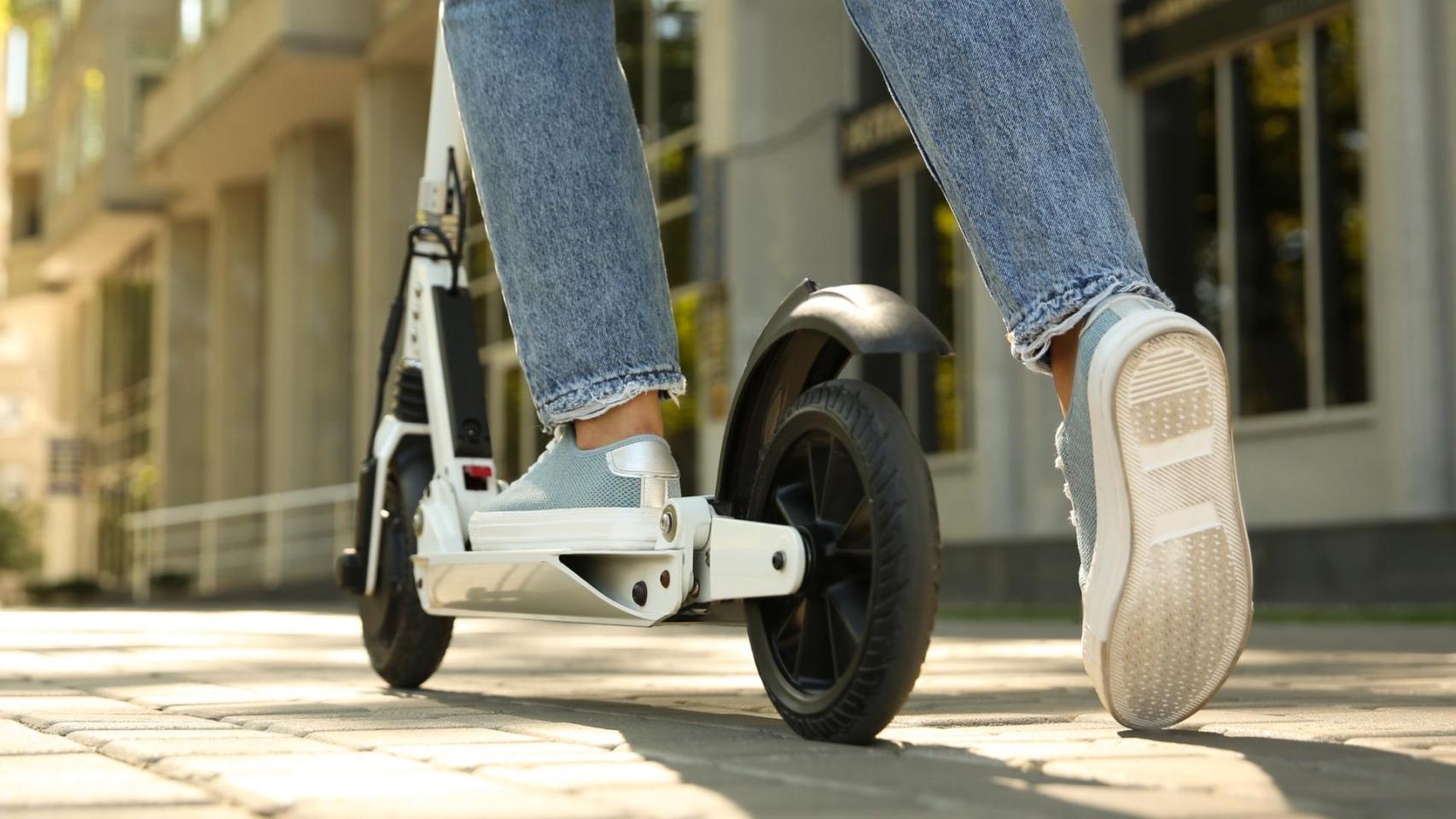Una mujer montando un patinete eléctrico