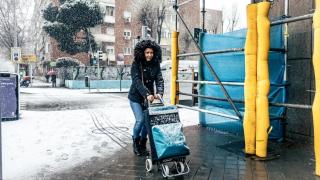 Una mujer se protege del frío mientras camina por Madrid.