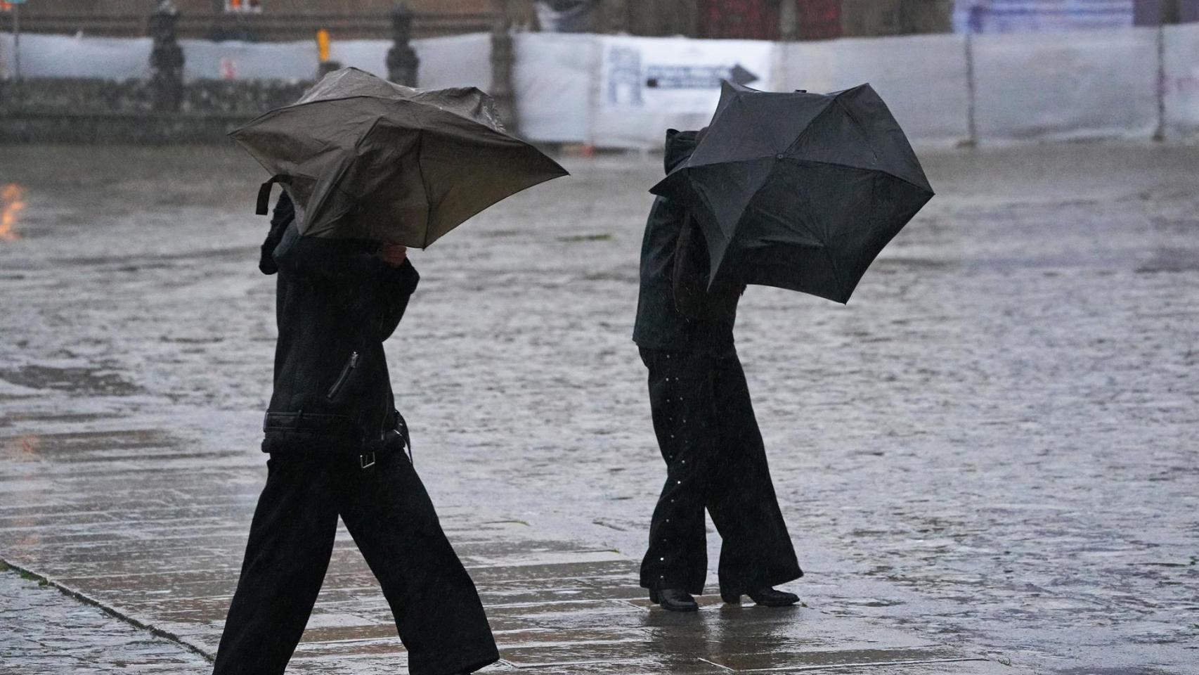 Varias personas intentan sujetar sus paraguas en medio del temporal esta semana.