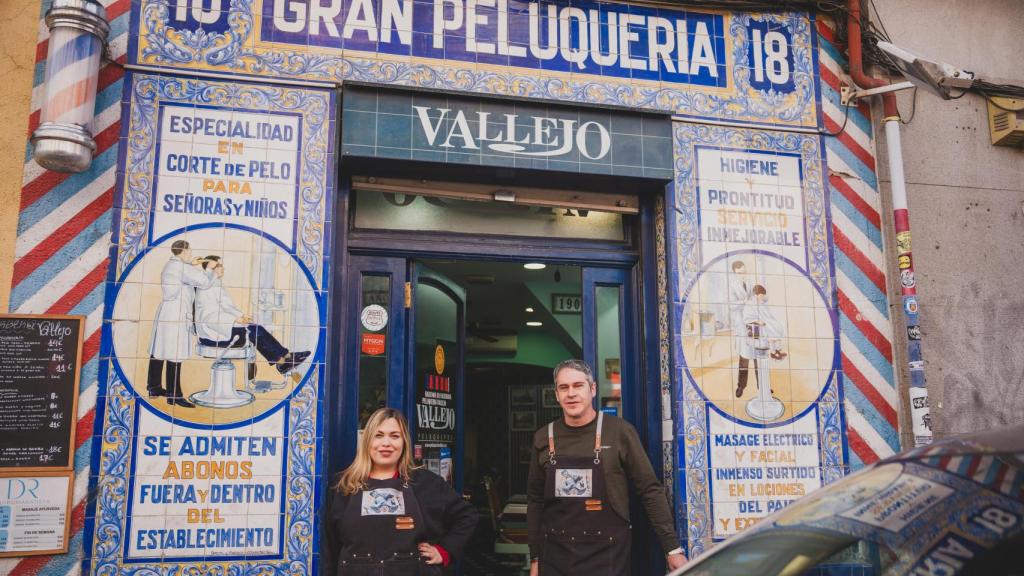 Lucía y José Carlos posan en la puerta de la peluquería más antigua de Madrid.