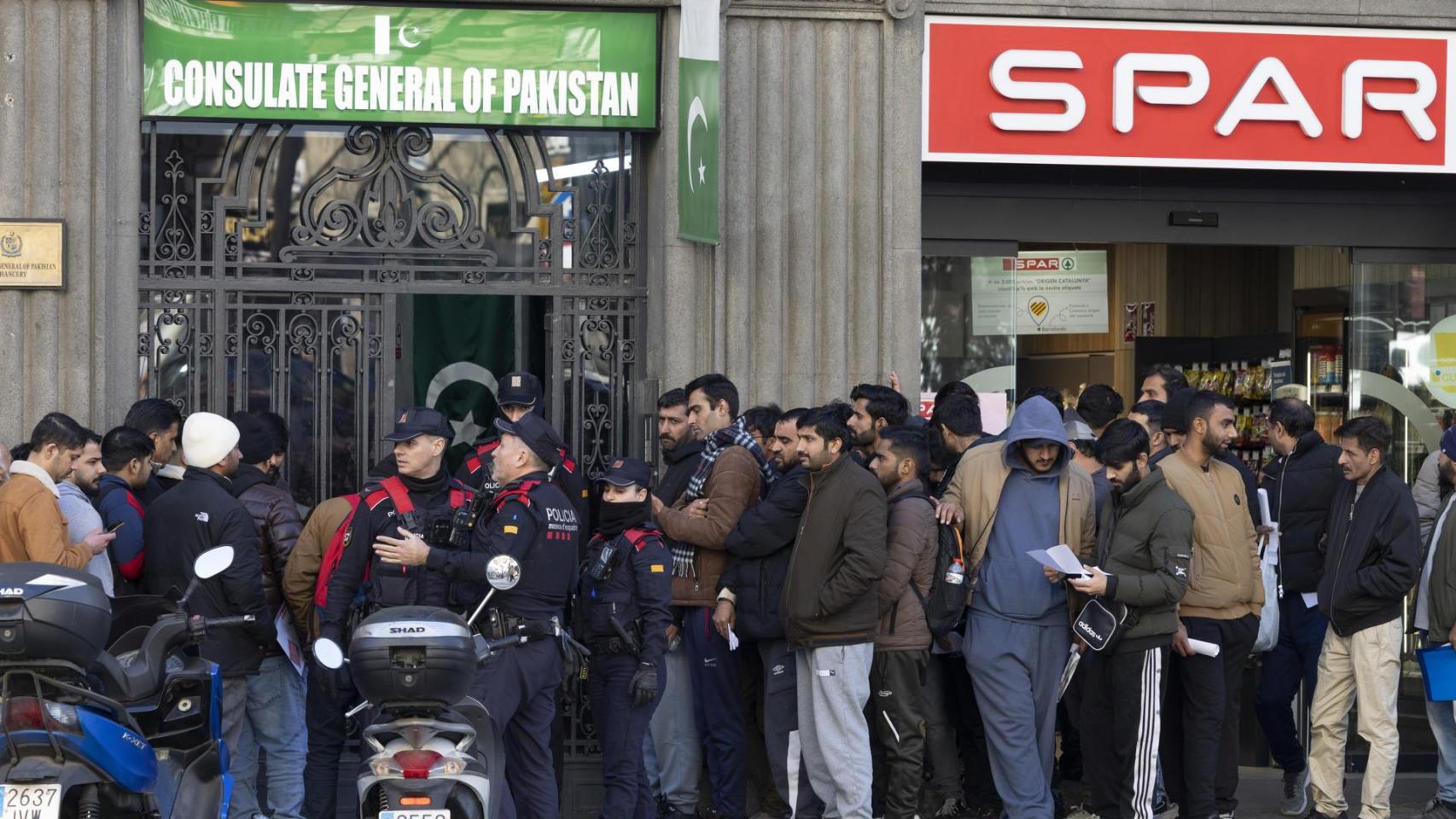 Inmigrantes hacen cola ante la puerta del consultado de Pakistán en Barcelona, el pasado jueves, para pedir su certificado de antecedentes con el fin de acogerse al proceso de regularización.