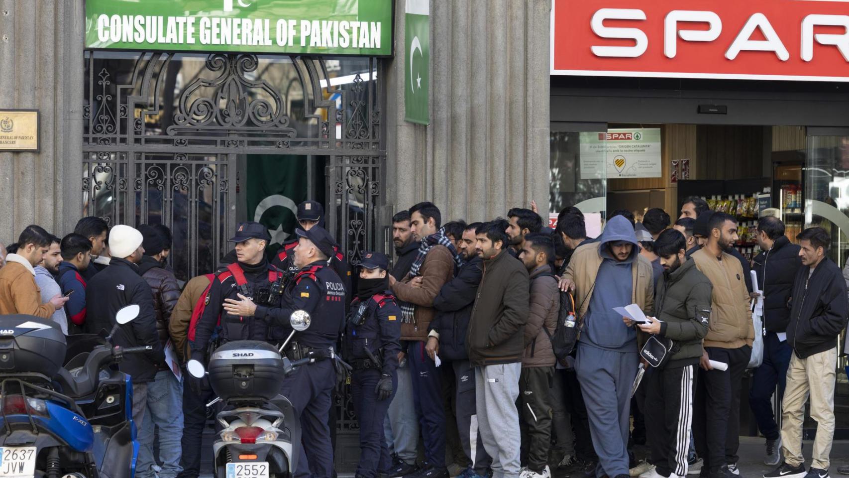 Inmigrantes hacen cola ante la puerta del consultado de Pakistán en Barcelona, el pasado jueves, para pedir su certificado de antecedentes con el fin de acogerse al proceso de regularización.