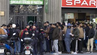 Inmigrantes hacen cola ante la puerta del consultado de Pakistán en Barcelona, el pasado jueves, para pedir su certificado de antecedentes con el fin de acogerse al proceso de regularización.