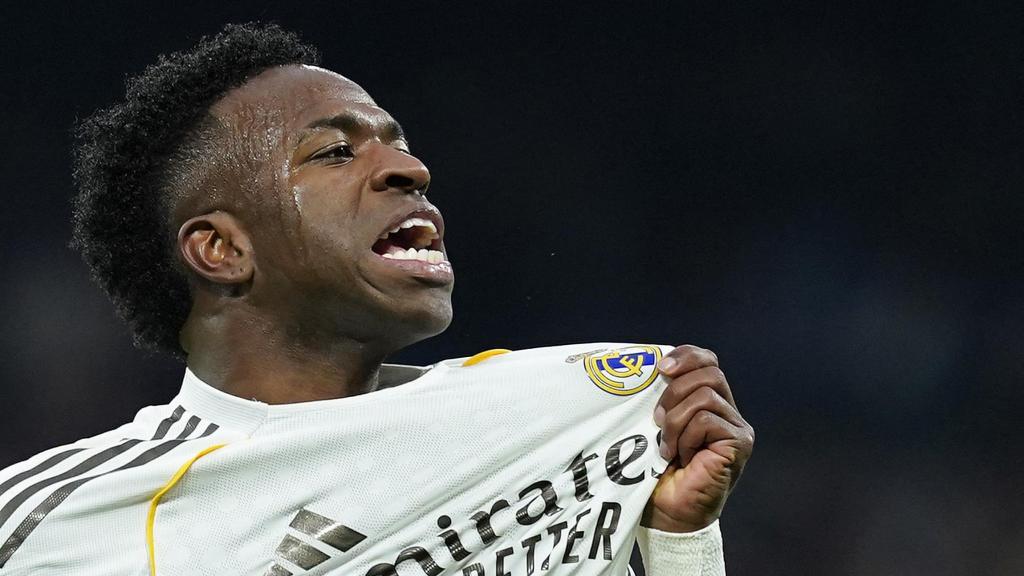 Vinicius celebra un gol agarrando el escudo del Real Madrid