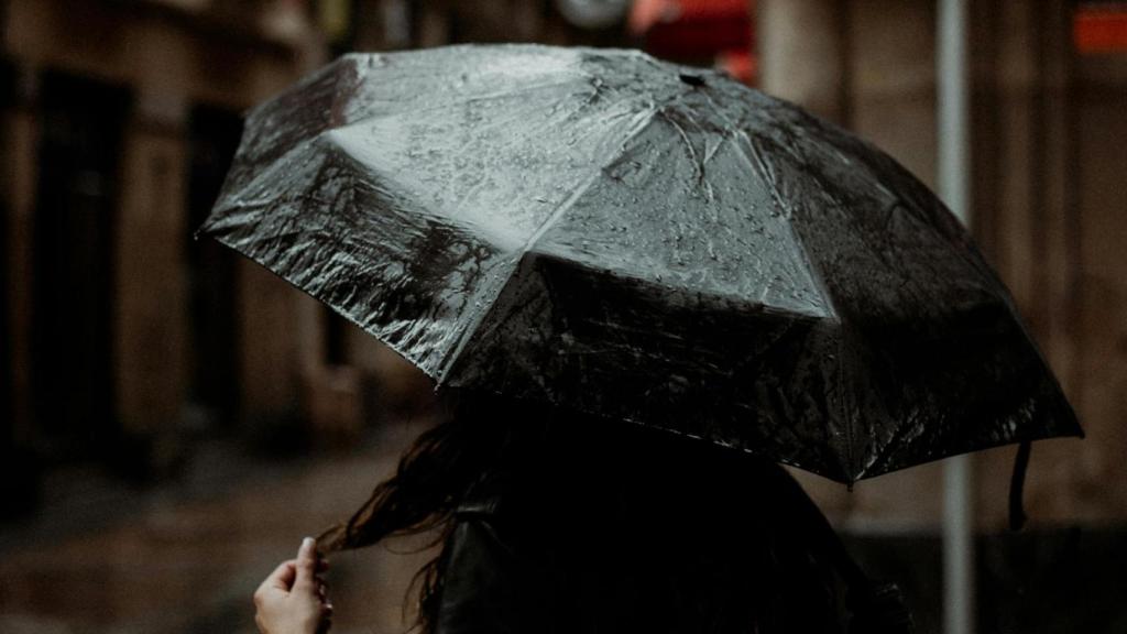 Una persona caminando bajo la lluvia.