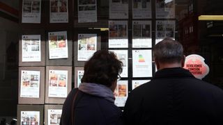 Una pareja observa anuncios de una inmobiliaria en Valladolid