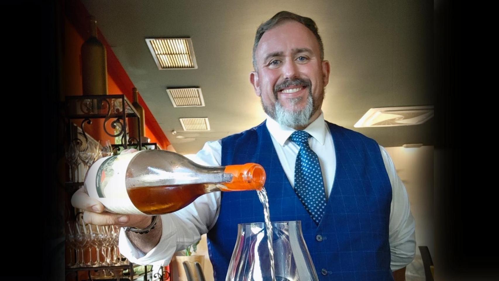 Adán sirviendo una copa de vino.