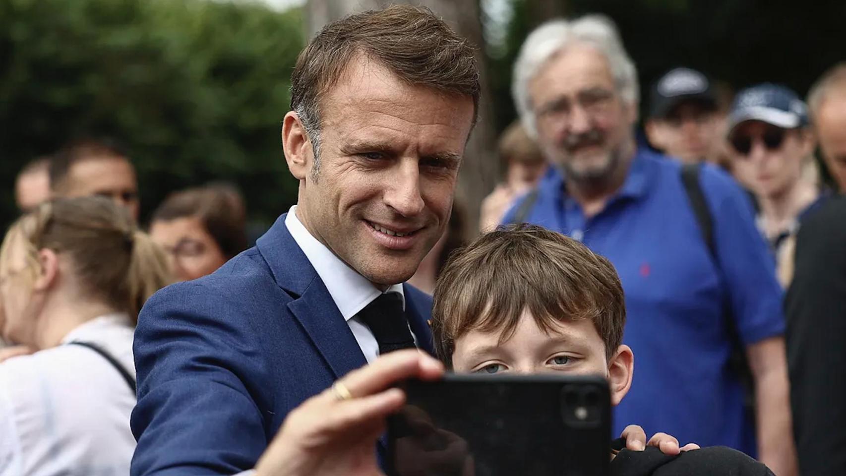 Emmanuel Macron se hace un selfi con un niño.