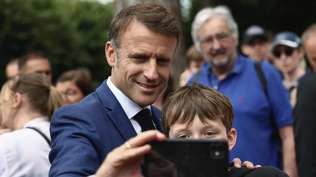 Emmanuel Macron se hace un selfi con un niño.