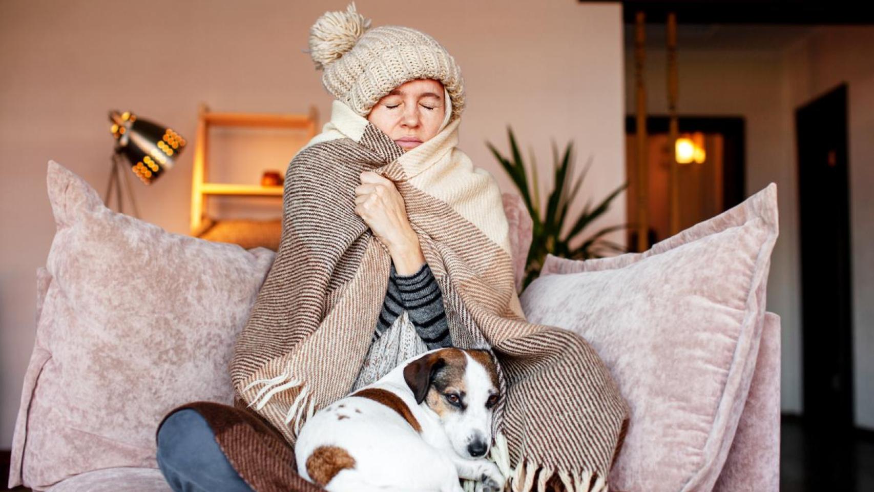 Mujer muy abrigada en casa.