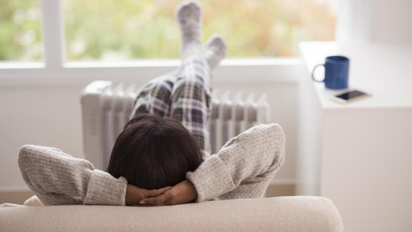 Una mujer con los pies sobre el radiador.