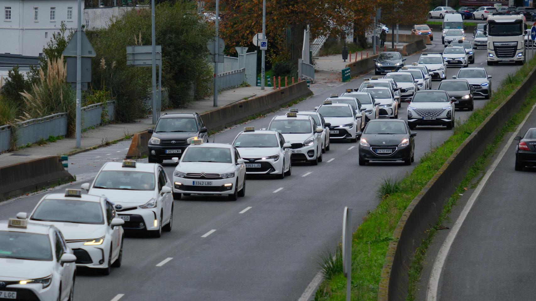 Taxis en fila circula por A Coruña en una protesta contra los VTC.