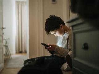 Niño con un teléfono móvil en su hogar.