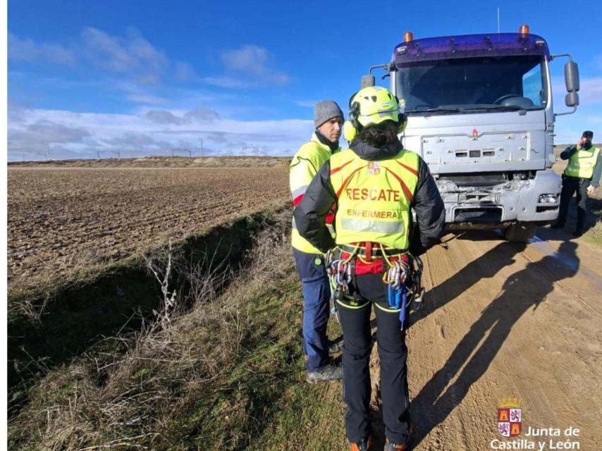 Dos efectivos de emergencias junto al camión que ha sufrido el accidente con el tren en Matapozuelos