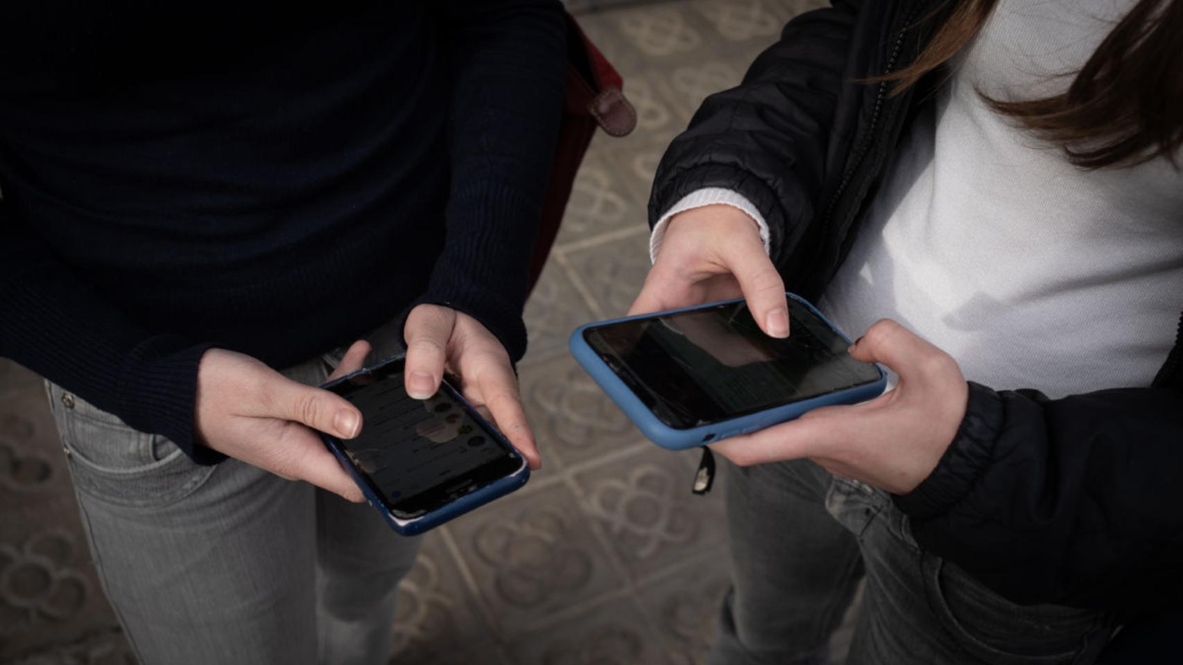 Imagen de archivo de dos jóvenes utilizando su teléfono móvil.