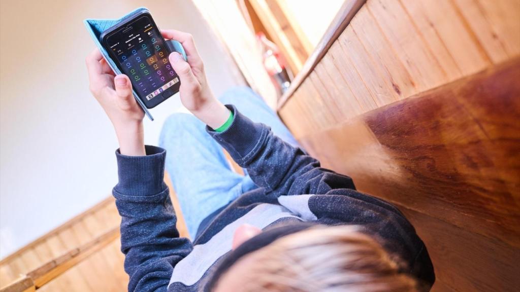 Imagen de archivo de un niño con teléfono móvil. Annette Riedl / dpa