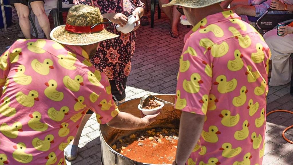 Dani y José repartiendo raciones de caldereta.