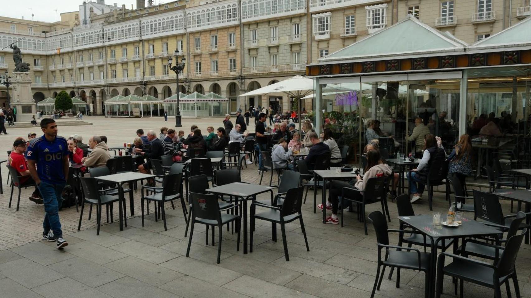 Clientes en terrazas de la plaza de María Pita de A Coruña sobre el pavimento y sobre tarima.