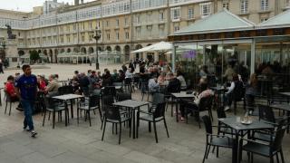 Clientes en terrazas de la plaza de María Pita de A Coruña sobre el pavimento y sobre tarima.