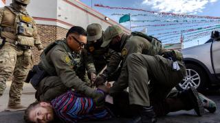 Un manifestante que sostiene una bandera estadounidense es arrestado por un agente del ICE durante una protesta en Broadview, Illinois, el 12 de septiembre.
