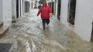 Un vecino de Grazalema (Cádiz) camina por una calle inundada debido a las intensas lluvias registradas este miércoles en el municipio.
