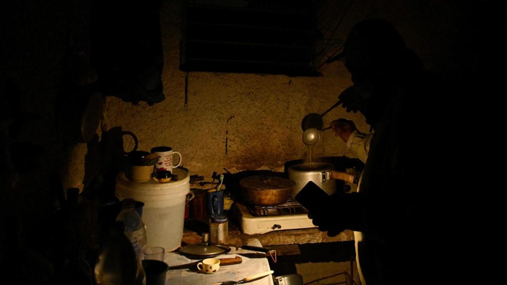 Un cubano prepara la cena en su casa durante un apagón en La Habana.