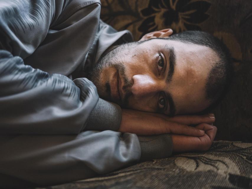 Un superviviente de las prisiones sirias descansa tras su liberación, marcado por años de detención y violencia.