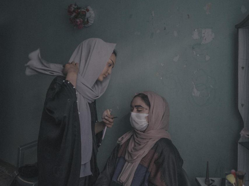Una joven maquilla a otra mujer en un espacio íntimo, uno de los pocos lugares donde las afganas pueden seguir expresándose con libertad.