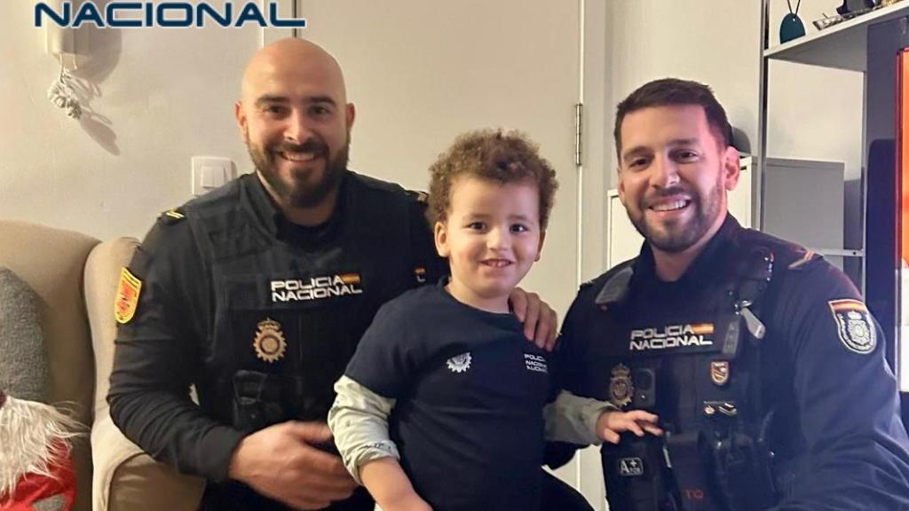Los dos agentes junto al niño de 3 años.