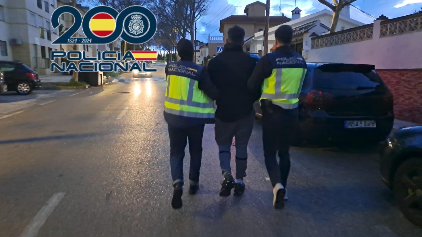 Dos agentes de Policía Nacional con uno de los detenidos.