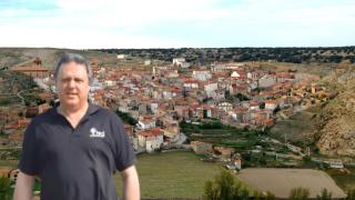 Ovidio Ortín y su pueblo detrás.