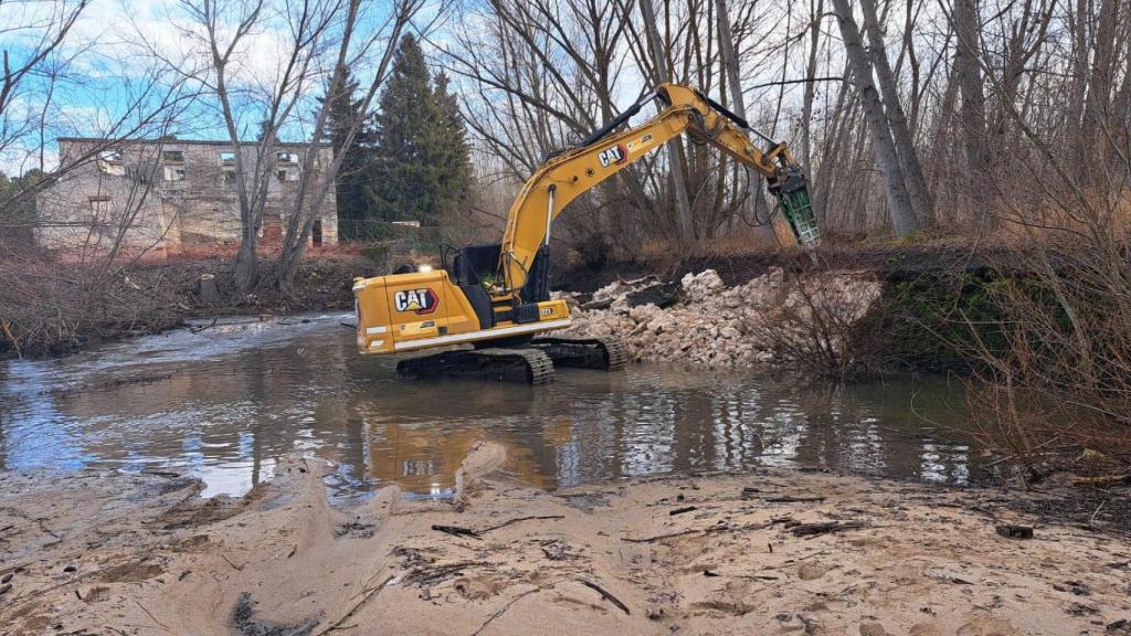 Imagen de la maquina, ya por la mañana, mientras derruía el azud de Puente Mesa
