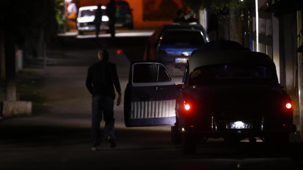 Una persona camina frente  en una calle poca iluminada de La Habana como consecuencia de la crisis energética