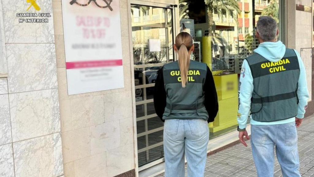 Agentes de la Guardia Civil en la óptica asaltada.